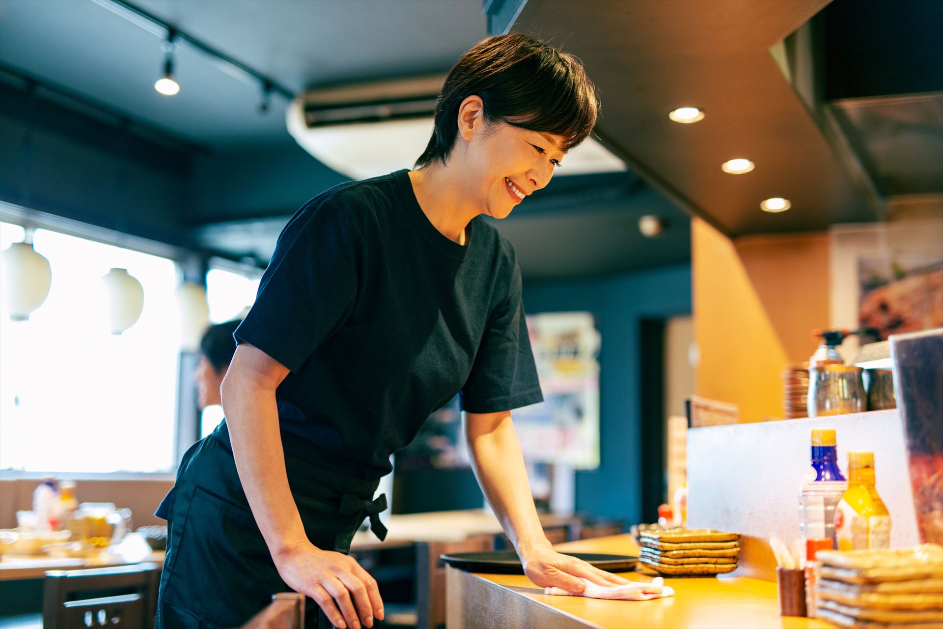 カウンター席を拭女性スタッフ